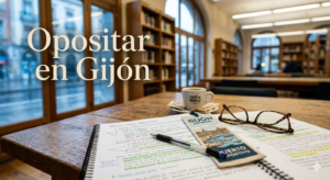 Mesa de estudio en una biblioteca pública de Gijón con temarios de oposición listos para estudiar.